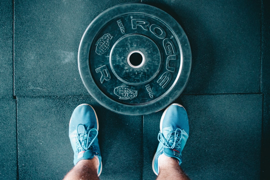 A home gym setup with protective flooring, showcasing weights and exercise equipment.