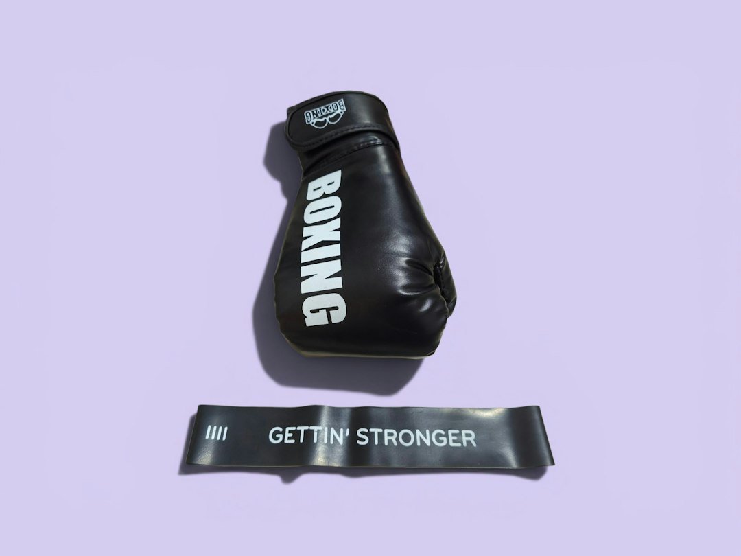 Black boxing glove and "gettin' stronger" resistance band on purple